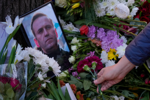 A man lays flowers beneath a framed photo of Alexei Navalny during protest in front of Russian embassy in Belgrade, Serbia on February 16, 2024.