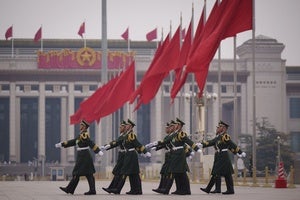 Chinese soldiers march to their post outside the Great Hall of the People in Beijing