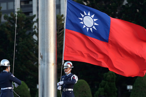Two soldiers lower the Taiwan national flag at the Chiang Kai-shek Memorial Hall in Taipei, Taiwan on April 29, 2025.
