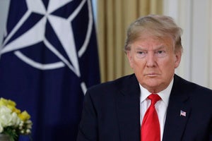 US President Donald Trump in front of a NATO flag