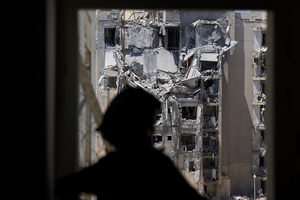 A police officer inspects a damaged apartment a day after a direct missile strike from Iran hit a residential building in Beersheba, Israel on June 25, 2025.