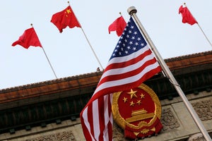 An American flag is flown next to the Chinese national emblem and flags