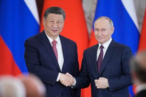 Russian President Vladimir Putin and Chinese President Xi Jinpin shake hands at the Kremlin