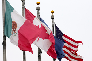 Flags of Mexico, Canada, and the United States flying from flagpoles.