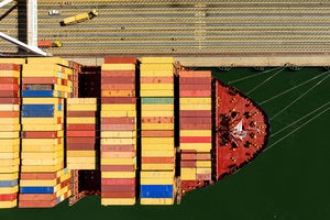 Cargo containers line a ship at the Port of Oakland