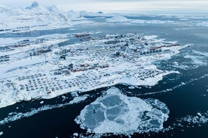 Houses covered by snow are seen on the coast of Greenland