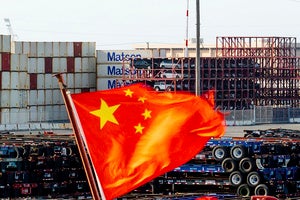 Photograph of Chinese flag in front of shipping containers