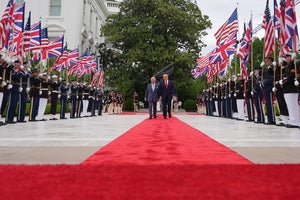 President Donald Trump walks on the red carpet in the Rose Garden with Britain's King Charles III