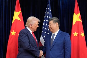 Trump and Xi Jinping shaking hands in front of US and Chinese flags