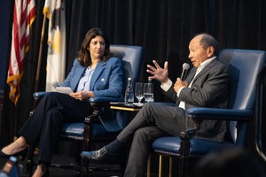Two people speaking on a stage.