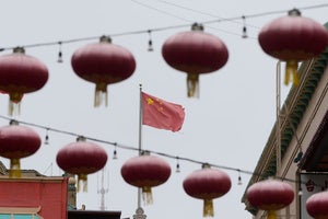 A flag of China is shown between lanterns hanging in Chinatown in San Francisco