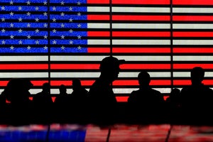 Silhouettes against a backdrop of the American flag