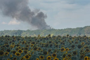 Smoke rises above warehouse stores behind a sunflower field following a Russian air attack in Kyiv, Ukraine