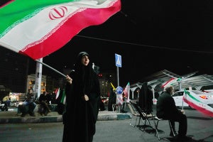 A woman waves an Iranian flag during a pro-government gathering at a square in Tehran, Iran, Tuesday, Aug. 11, 2026. 