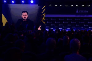 People watch Ukrainian President Volodymyr Zelenskyy on a large screen as he speaks at the Warsaw Security Forum in Warsaw, Poland, Monday, Oct. 12, 2026.