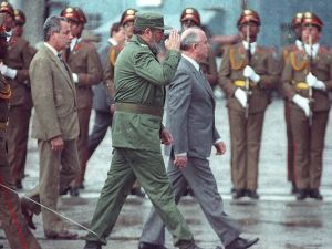 Men walking in front of a line of military in Cuba