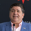Governor Pritzker stands behind a podium, speaking into a microphone