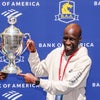Wesley Korir holding up a trophy at the 2025 Boston Marathon.