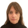 Woman with bangs in black turtleneck