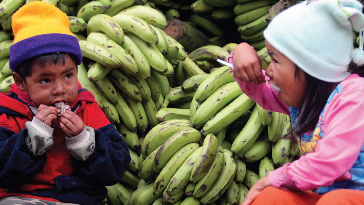 Children sit and eat outside in La Paz, Bolivia.