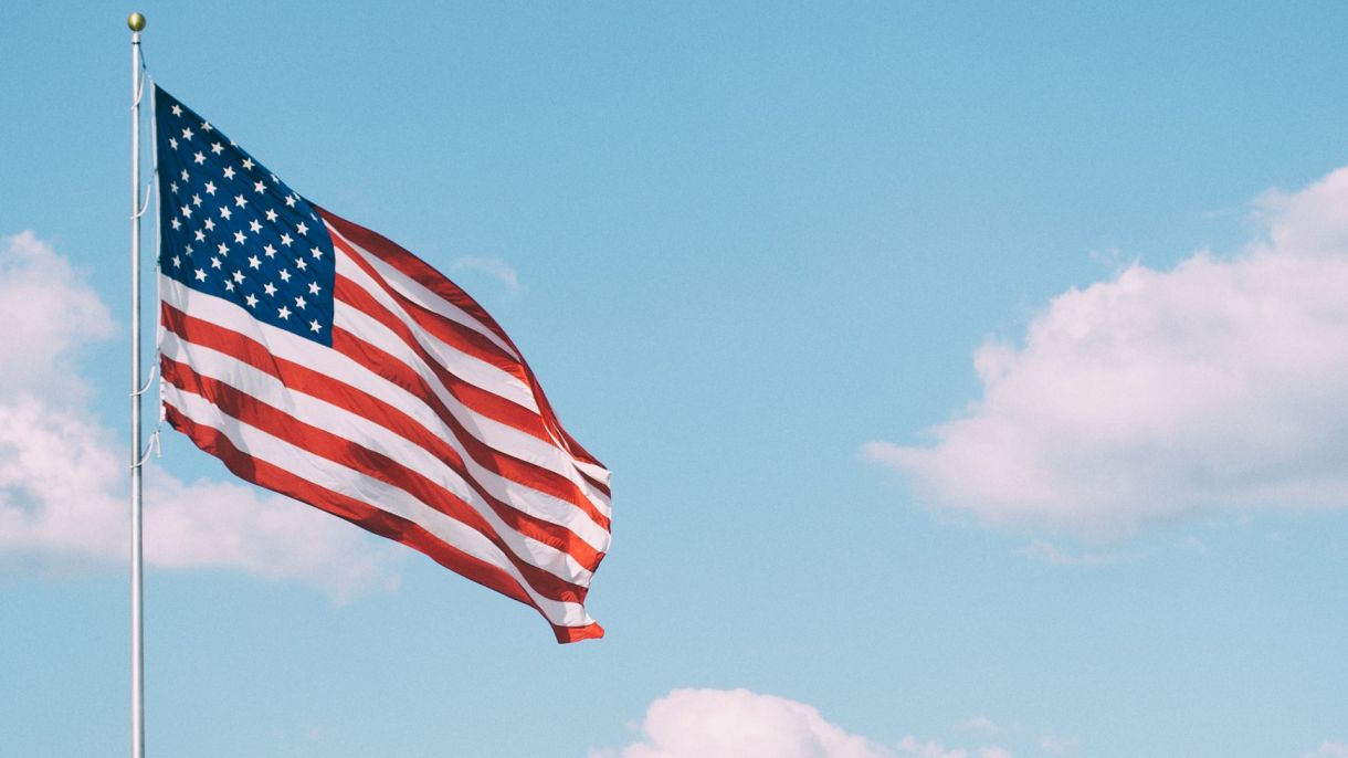An American flag waving against a blue sky