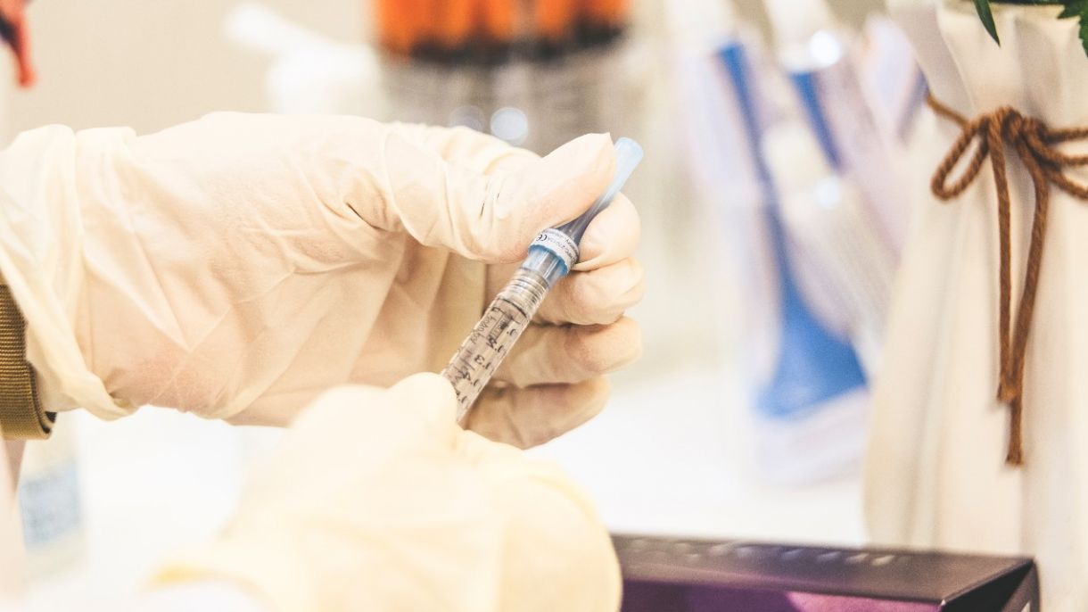 a medical professional prepares a vaccine syringe