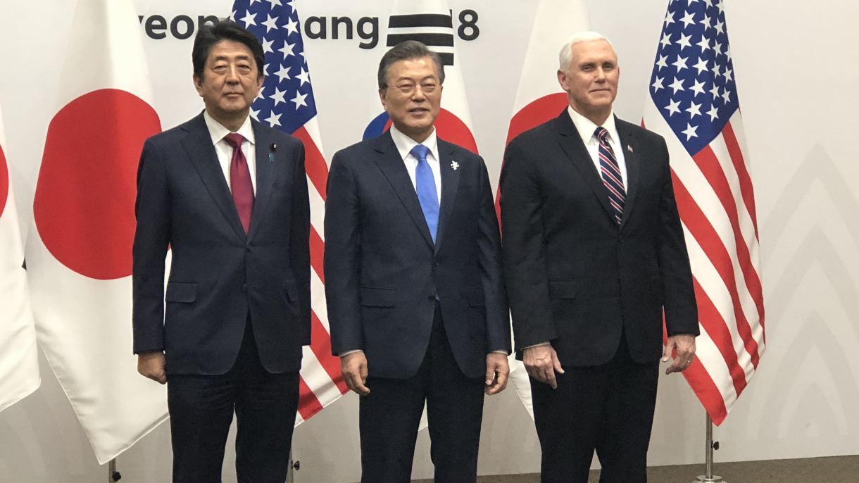 Shinzo Abe, Moon Jae-in, and Mike Pence standing side by side.