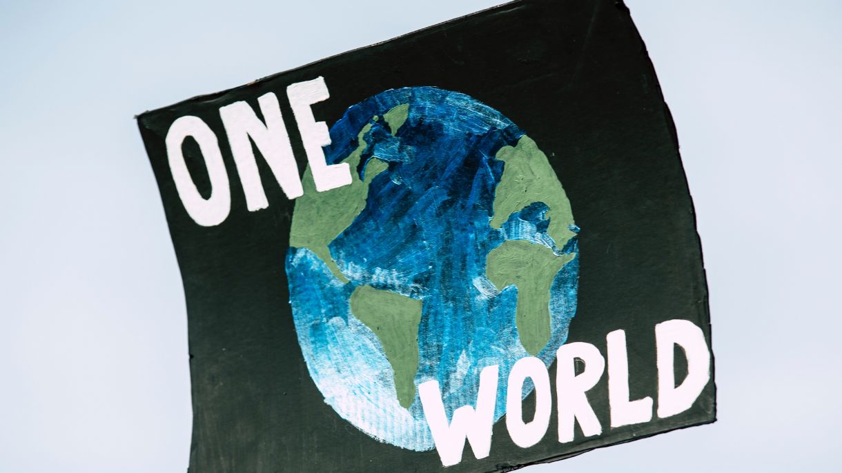 Poster with the image of earth and the text "One World"