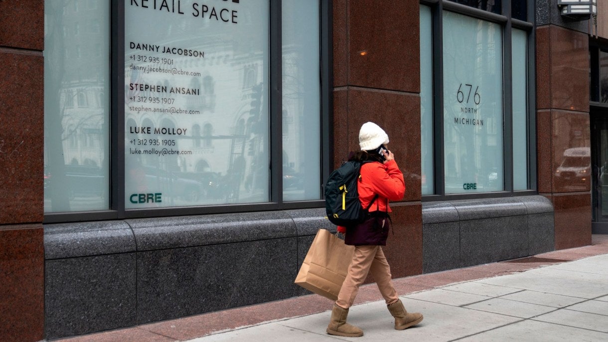 A person walks past an empty storefront
