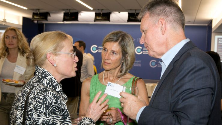 Three people talk during a Council event reception