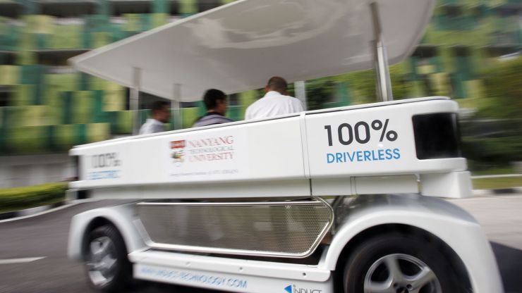An autonomous vehicle shuttle drives in Singapore, with blurred background