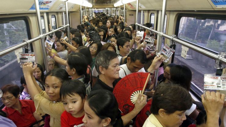 People stand on a crowded train in Manila