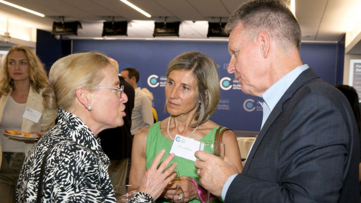 Three people talk during a Council event reception