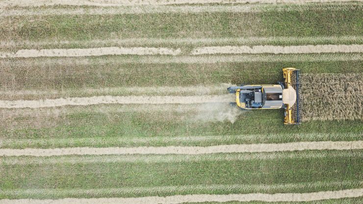 An aerial view of a tractor ploughs a field 