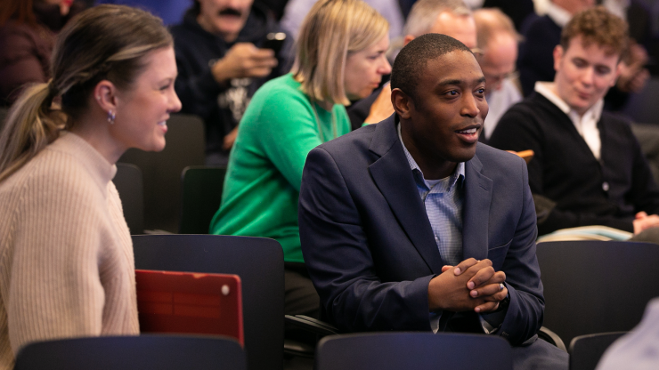 Two people in the audience at a Council event