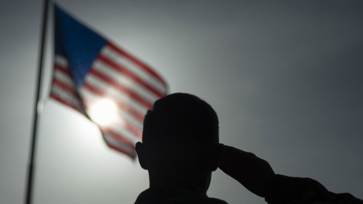 a person salutes an American flag