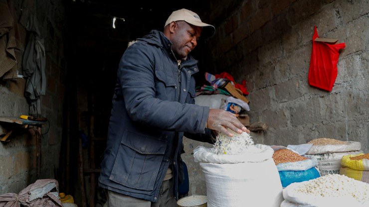 Vendor Francis Ndege measures rice at his stall in the Toi Market, Nairobi, Kenya.
