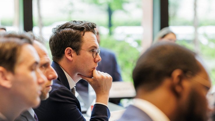 A person sits at a table during a meeting