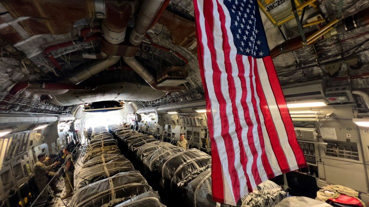 a flag hangs over bundles of US aid
