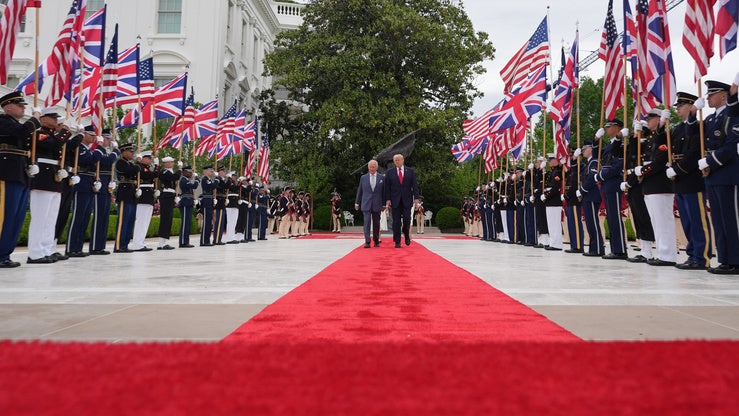 US President Donald Trump and King Charles III walk down a red carpet