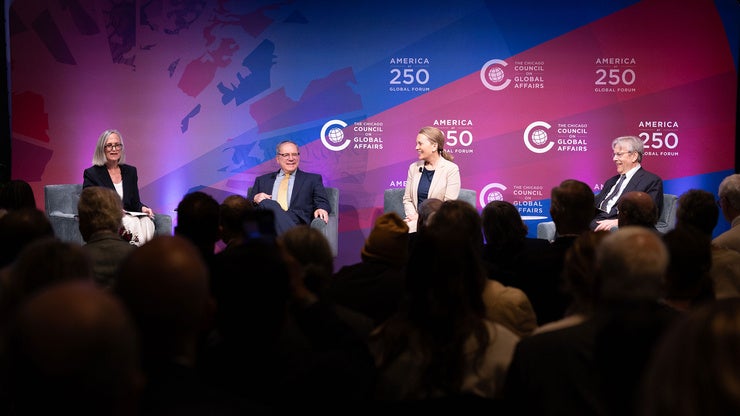 Four people sit on stage in front of an audience