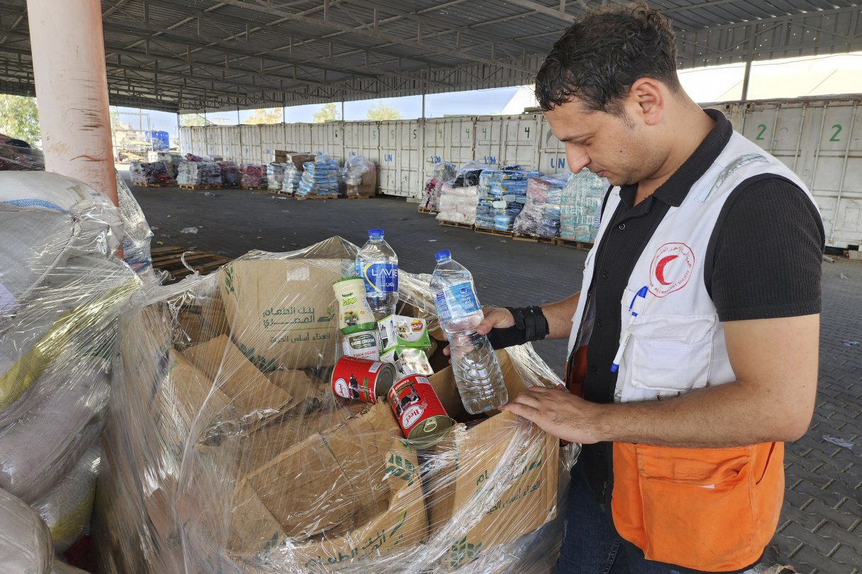 United Nations and Red Crescent workers prepare the aid for distribution to Palestinians at UNRWA warehouse in Deir Al-Balah, Gaza Strip, on Monday, Oct. 23, 2023.