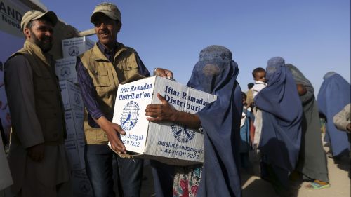 Afghan woman receives a box of food.