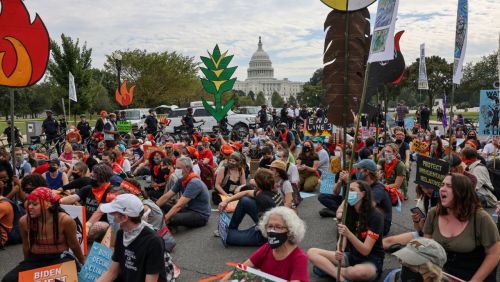 Crowd kneels at a climate protest.