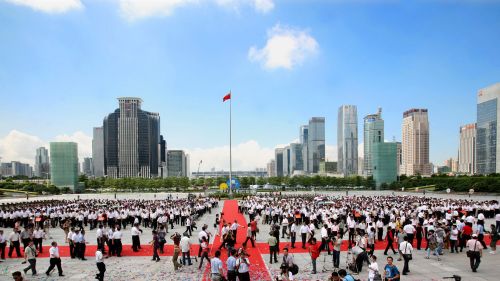 Chinese officials and citizens are seen during a ceremony against the cityscape of Shenzhen