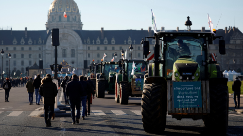 : French farmers gather with their tractors near the Invalides during a protest over pesticide restrictions and other environmental regulations they say are threatening agricultural production, in Paris, France, February 8, 2023. The slogan reads, "Don't import the agriculture we don't want.”