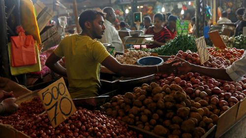 A vendor exchanges money with a customer at a main market in Colombo, Sri Lanka. Sri Lanka is trying to climb its way out of the economic and political chaos that ensued when it defaulted on its sovereign debt in May 2022.