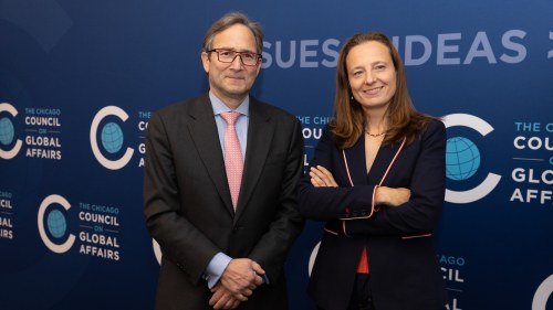 John Ettelson and Sarah Gilbert stand in front of Council blue wall with logos and "Issues, Ideas, Impact" written behind them.