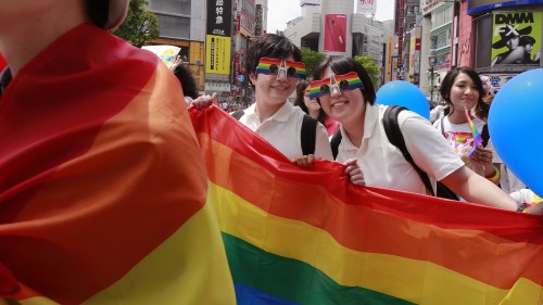 Participants smile as they march with a banner during the Tokyo Rainbow Pride