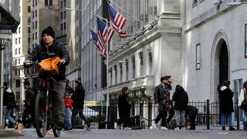 People pass in front of the New York Stock Exchange on March 21, 2023.